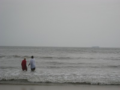 med-IMG_0747 I also loved watching these two gentlemen--I think a son and his elderly father. The son finally got dad into the water and were rewarded by a close encounter with a pair of dolphins. They are gazing at where the dolphins just were...about three wave crests directly in front of them.